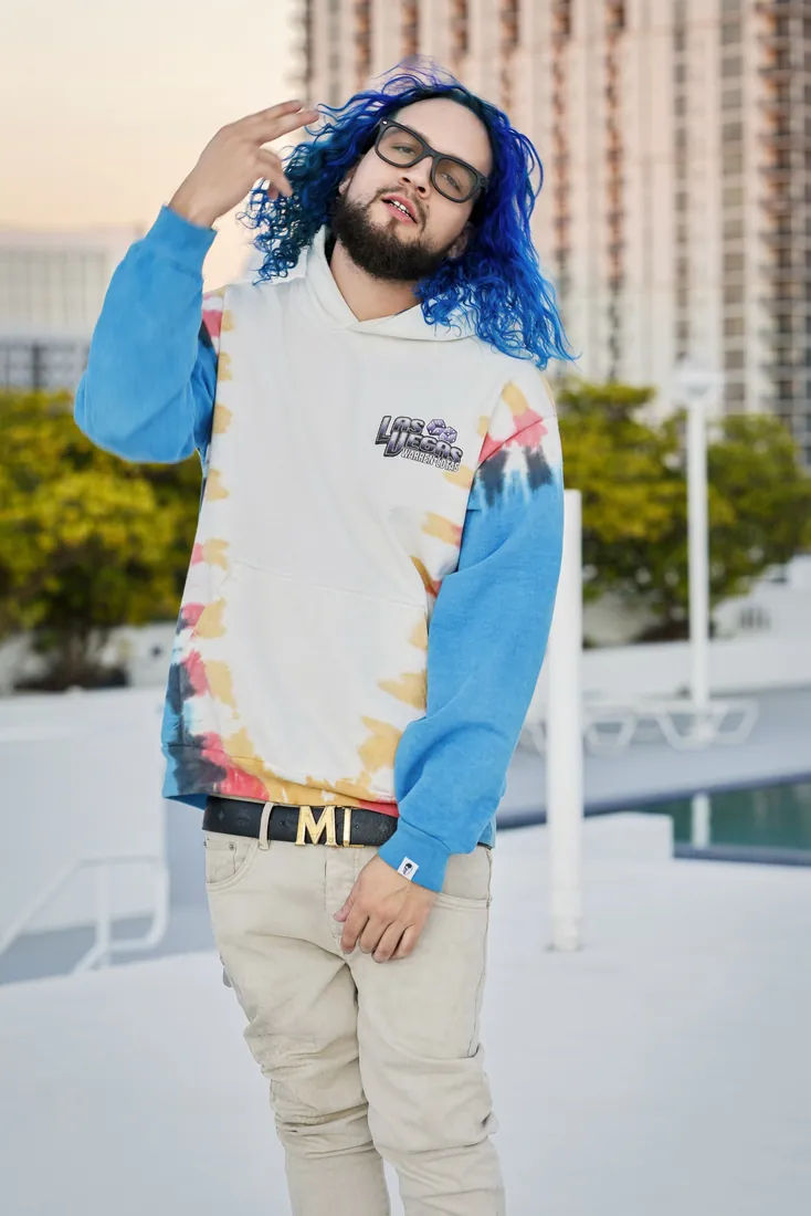 Fly South standing outdoors in a white and blue hoodie